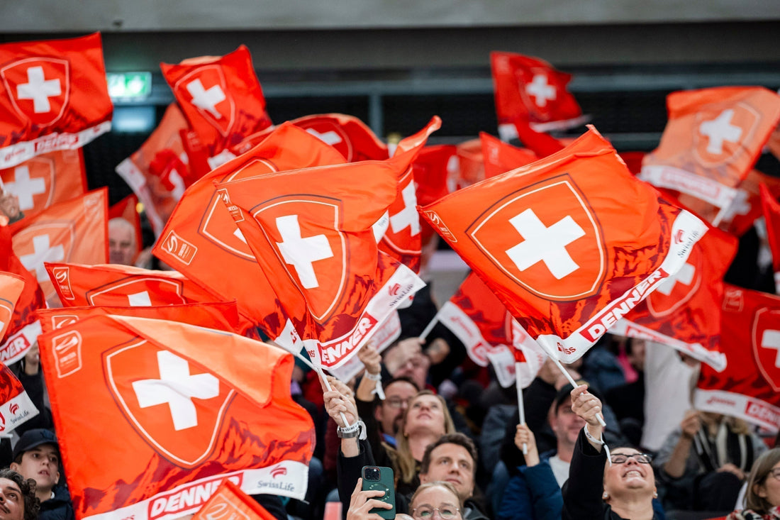 Fans im Stadion schwenken Schweizer Flaggen und unterstützen die Schweizer Eishockey-Nationalmannschaft – Sinnbild für die Leistungsumgebung, in der Athleten auf Dagsmejan Nachtwäsche zur Regeneration setzen